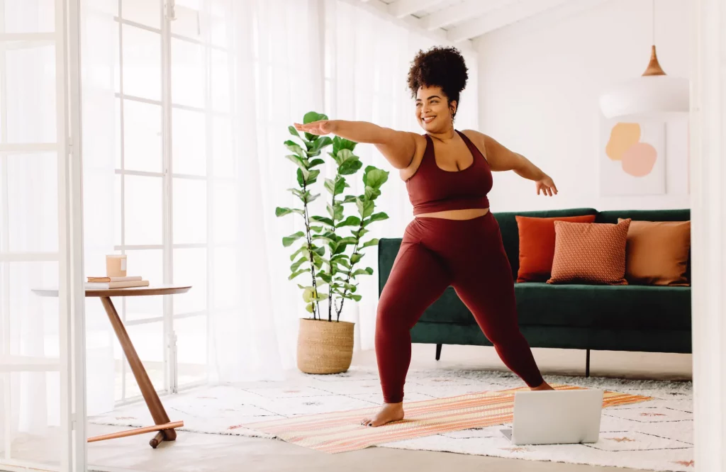 Eine Frau praktiziert Yoga in ihrer Wohnung.