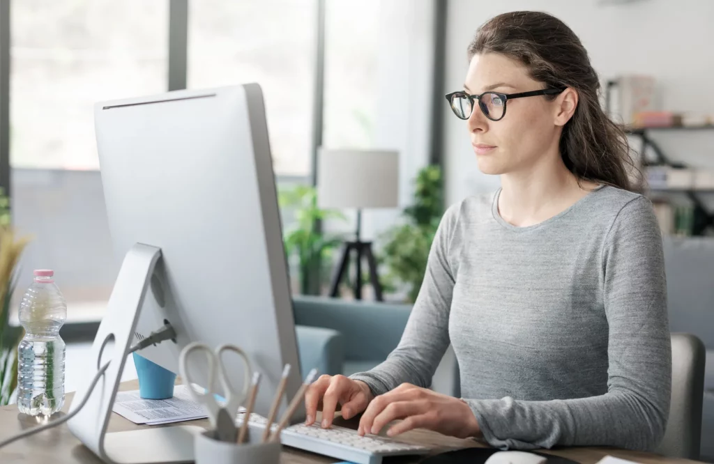 Eine Frau arbeitet professionell an ihrem Schreibtisch im Homeoffice.