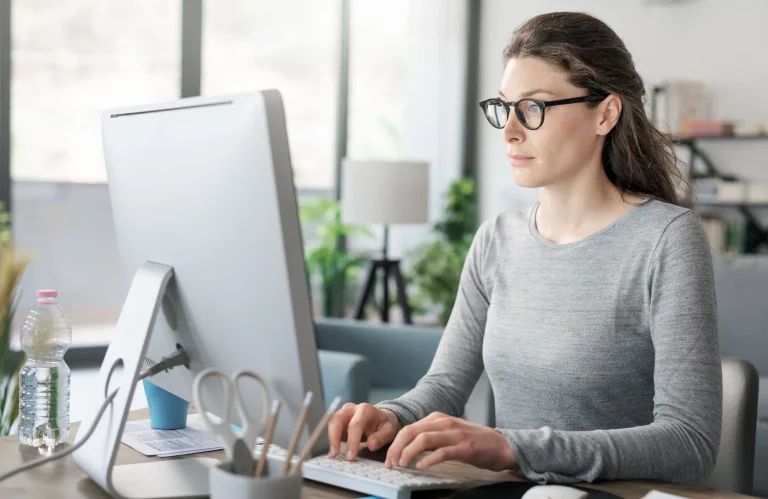 Eine Frau arbeitet professionell an ihrem Schreibtisch im Homeoffice.