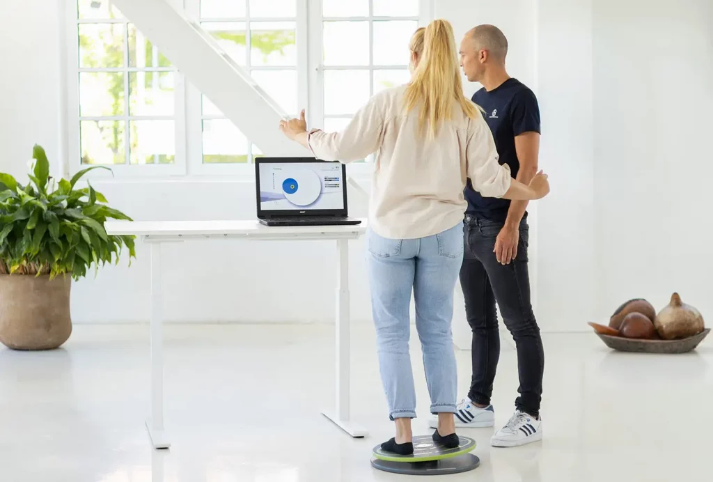 GiB-Trainer bei der Durchführung eines Stabilitätstests mit einer Teilnehmerin auf der Balance-Disc.