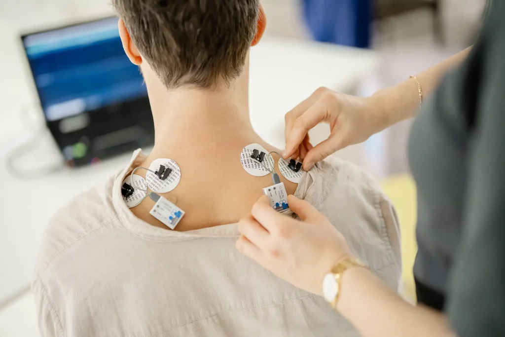 Nahaufnahme der Elektroden-Platzierung für eine EMG-Muskeltonusmessung zur Analyse von Muskelspannung und Dysbalancen.