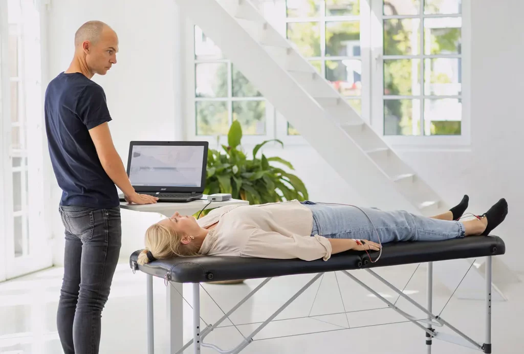 GiB-Trainer bei einer bioelektrischen Impedanzanalyse (BIA) zur Bestimmung der Körperzusammensetzung bei einer Teilnehmerin.