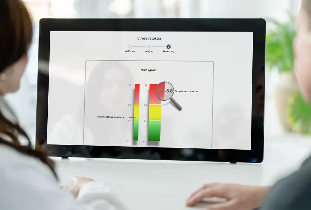 GiB-Trainer und Teilnehmerin beim digitalen Stressdetektor an einem Touch-Display.