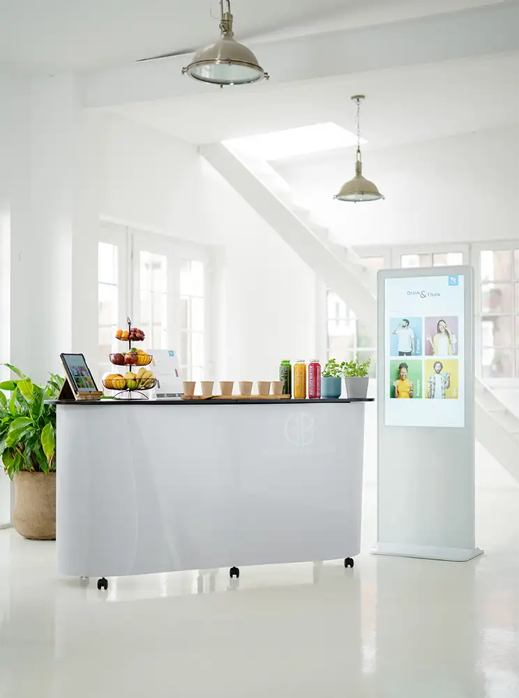 Interaktive Smoothie-Station „Drink & Think“ mit verschiedenen Smoothies in Glasflaschen und digitaler Beratung per Tablet und Touch-Stele.