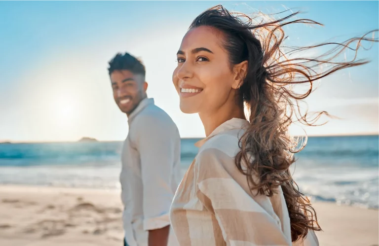 Eine glückliche Frau und ein glücklicher Mann sind am Meer und genießen das Leben.