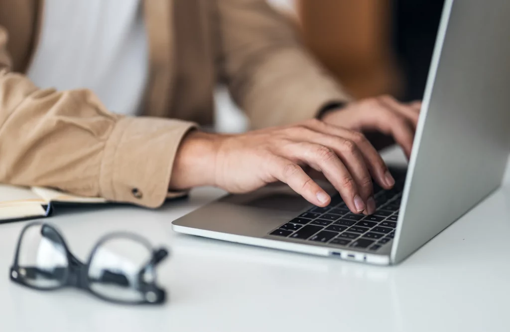 Eine Person tippt auf einer Laptop-Tastatur.