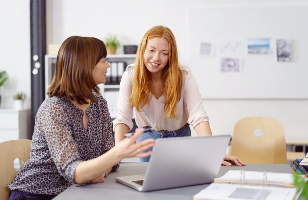 Eine Führungskraft und eine Mitarbeiterin unterhalten sich im Büro.