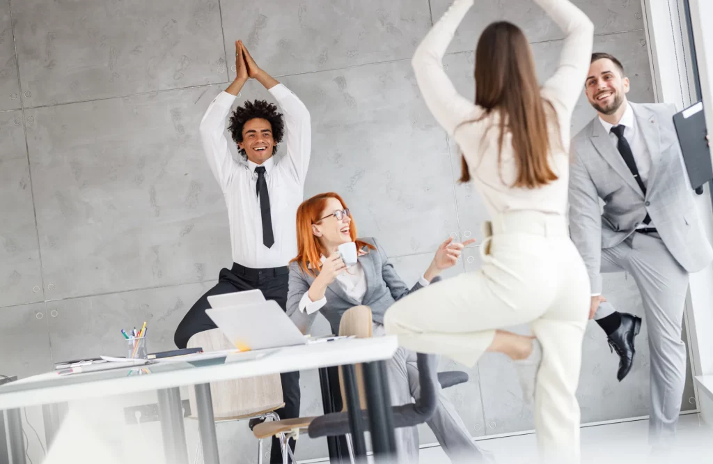Büroangestellte nutzen ihre Kaffeepause für Yoga-Übungen, um nach einem stressigen Tag zu entspannen.