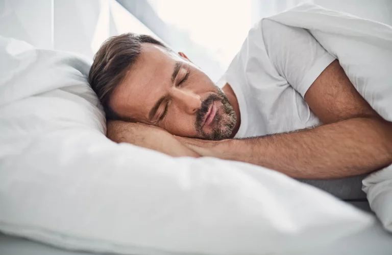 Ein Mann schläft in einem Bett.